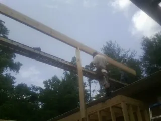Carpenter setting a ridge beam over a new addition frame — Ice Dam Removal by Roofing Brothers in Munster