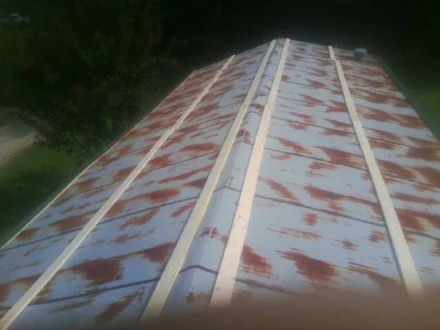 Rusted metal roof panels with new wood purlins before replacement — Storm Damage Roof Repair in Munster by Roofing Brothers